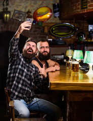 Man in bar drinking beer. Take selfie photo to remember great evening in pub. Online communication. Man bearded hipster hold smartphone. Taking selfie concept. Send selfie to friends social networks