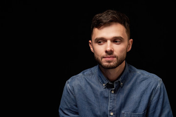 Thinking man in denim shirt looking sideways