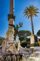 Monument to the Fallen of the War, in Piazza Guglielmo Marconi. Bronze statue of Winged Victory, large column and fountain with water jet. Frascati, Rome, Lazio, Italy, Castelli Romani, Roman Castles.