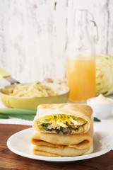 Vegetarian crepes with cabbage, mushrooms and cheese filling.
