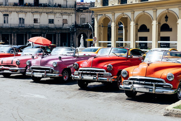 Naklejka premium Vintage american cars parked on the street near Central Park in downtown Havana,