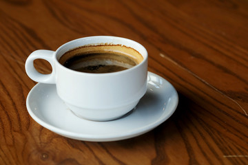 Well mixed hot black coffee in white coffee cup with space for write wording served in a restaurant in a coffee break time, popular drink for meeting place and party time, value added design for bette