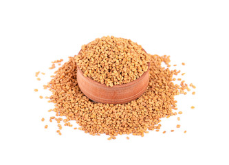 Fenugreek seeds in wooden bowl, isolated on white background.