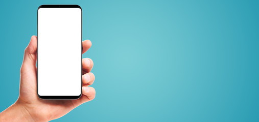 male hand holding bezel-less smartphone with blank screen, isolated on blue background . Screen is cut out with path - obrazy, fototapety, plakaty