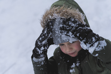 chłopiec bawi się śniegiem