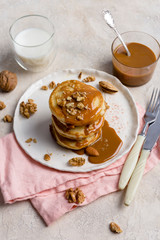 Stuck of pancakes with caramel on white plate