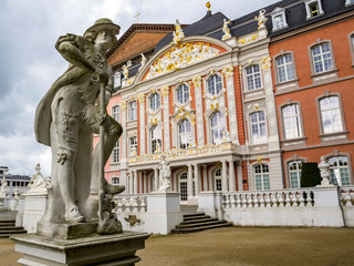Fototapeta na wymiar The Gardener - a statue by Ferdinand Tietz in front of the Electoral Palace and the Aula Palatina in Trier, Germany