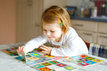 Adorable cute toddler girl playing picture card game at home or nursery. Happy healthy child...
