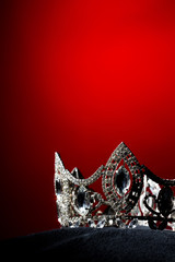 Silver Diamond Crown of Miss Pageant Beauty Universe World Contest sparkle light on black pillow, ready for wear Most beautiful Winner, studio lighting super red gradient background dramatic © Jade