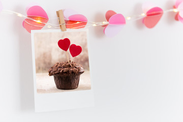 The polaroids photo red heart pinned on a lantern, white wall background.