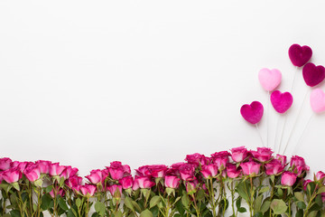Flowers composition. Frame made of red rose on white wooden background. Flat lay, top view, copy space.