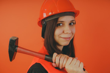 Girl construction worker, road worker or longshoreman, a woman in a helmet and orange vest