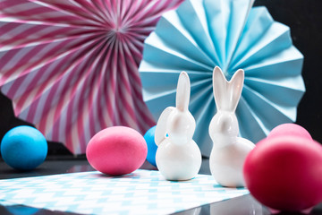Easter holiday background with eggs, porcelain bunny and paper decoration