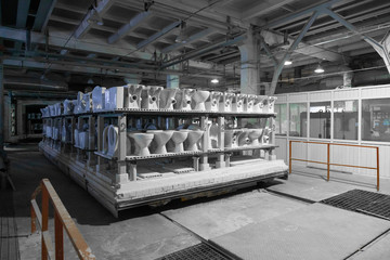ceramic toilets and sinks on the shelves in the production shop