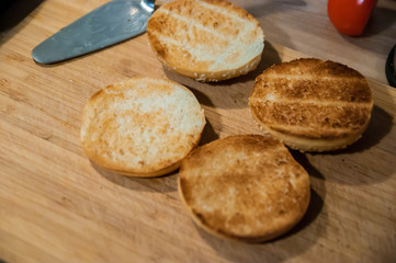 Burger buns with sesame seeds on a chopping board