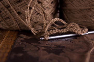 View of the part on the crochet hook and a knitted chain of yarn loops in dark beige tones. Concept...