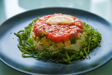 Hommemade kaisa salad with salmon, rice, avocado, sesame and lemon
