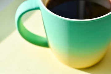 Cup in a bright color palette of turquoise shades with coffee, tea. Behind the Cup i