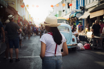 Little girl walking in thalang road with crowd of tourist in phuket.
