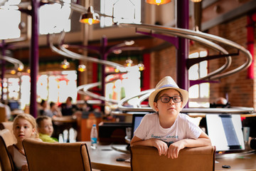 Fototapeta premium Restaurant and boy in the funny hat in the enterteiment park. RUSSIA, SOCHI, Sochi-park, june 2018