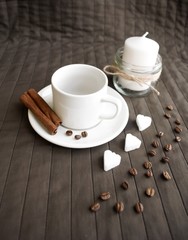 cup of coffee with sugar and a candle