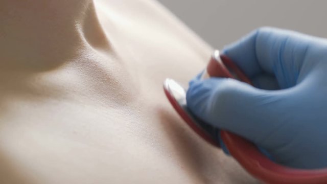 Close-up of doctor examining a patient with a stethoscope.