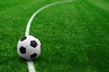 Soccer ball on green football field