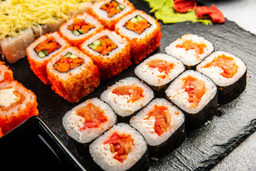 Big sushi set with variety of sushi rolls,on stylish dark background.