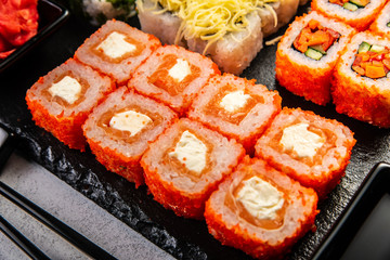 Big sushi set with variety of sushi rolls,on stylish dark background.