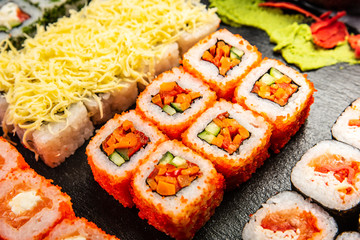 Big sushi set with variety of sushi rolls,on stylish dark background.