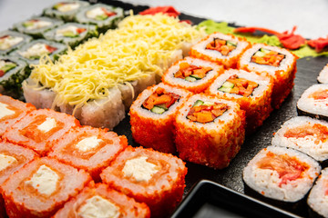Big sushi set with variety of sushi rolls,on stylish dark background.