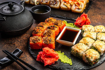 Big sushi set with variety of sushi rolls,on stylish dark background.