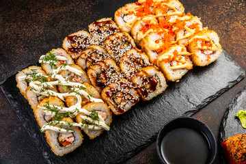Big sushi set with variety of sushi rolls,on stylish dark background.