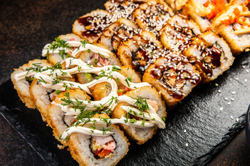 Big sushi set with variety of sushi rolls,on stylish dark background.