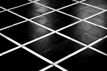 Die kontrastreiche Draufsicht auf die geometrisch angeordneten Bodenplatten einer Empfangshalle in schwarz weiß Muster.