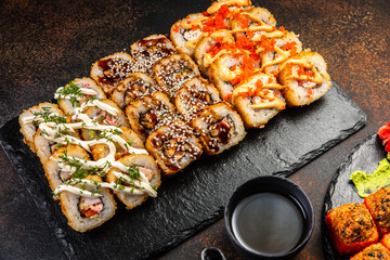 Big sushi set with variety of sushi rolls,on stylish dark background.