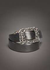 Silver gray leather belt with gemstones on gradient gray background