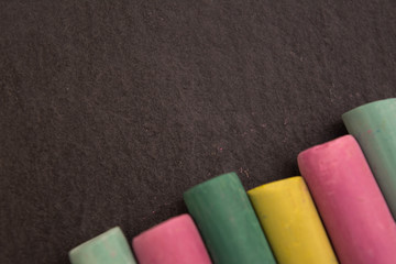 Colored chalk on a black background. Close-up. Place for text.