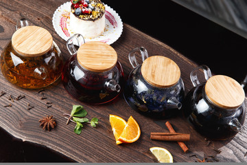various teas in teapots on a wooden table. selective focus