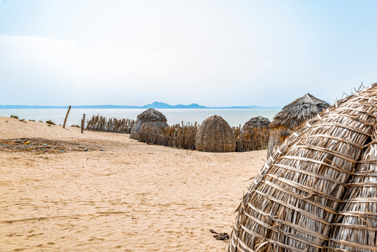 Partial view of traditional round bomas of semi-nomadic Turkana people, on shores of Lake Turkana, Kenya. The small dwellings are constructed from doum palm fronds, animal skins, timber. Copy space.
