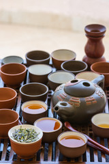 Authentic Chinese tea ceremony setting. Freshly brewed beverage poured in cups pot utensils on wooden dripping tray. Loose tea leaves. Lifestyle local culture. Wellness balance buddhist meditation
