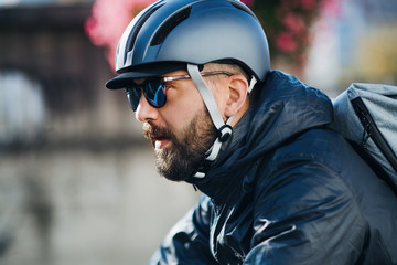 Male courier with bicycle delivering packages in city.