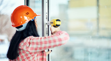 Girl builder in special clothes at the workplace.
