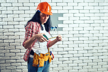 Girl builder in special clothes at the workplace.