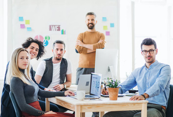 Group of young businesspeople with laptop working together in a modern office.