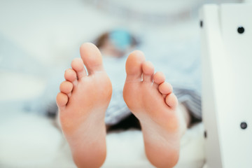 Naked feet of a young girl in bed, morning