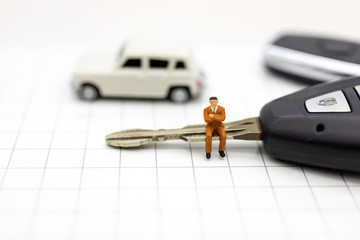 Miniature people : Businessman sitting on car key. Image use for Advertising product in the market today, competition on the business trading. © polymanu