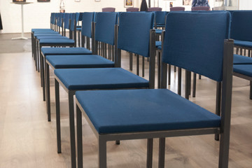 Rows of blue chairs in office meeting room.