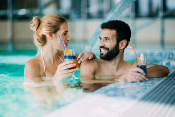 Happy attractive couple relaxing in swimming pool
