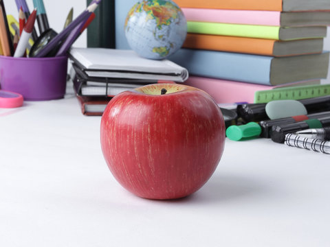 foreground a red Apple on the background of school supplies .photo with copy space